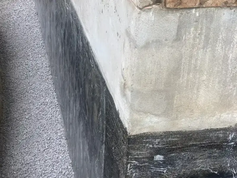 Membrane on the foundation wall down to the footing, with clear stone placed